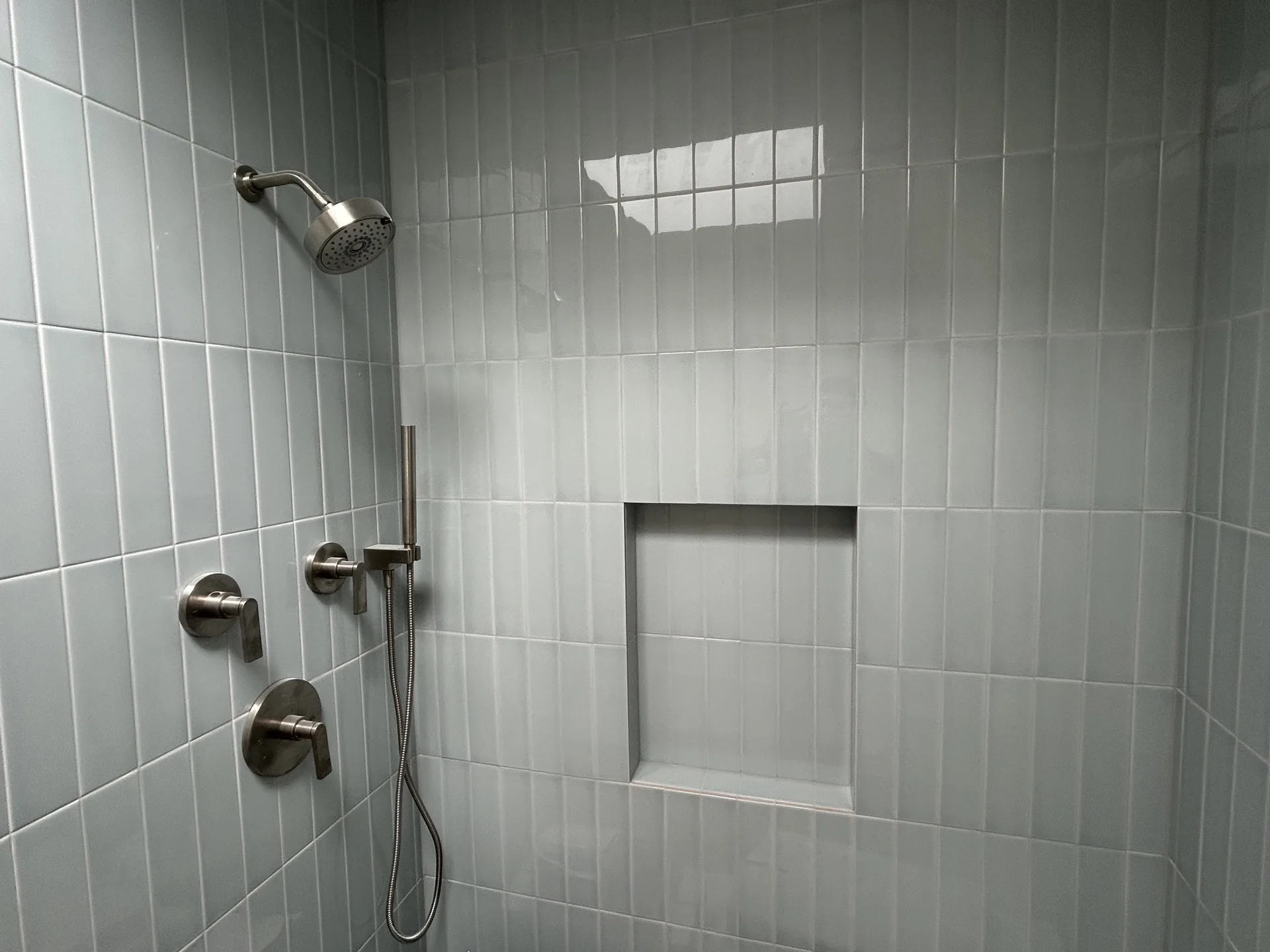 Stacked gray subway-tile shower with recessed niche and glass-block window