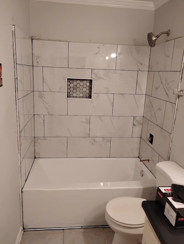 Tub and shower combination in marble-look tile with recessed niche