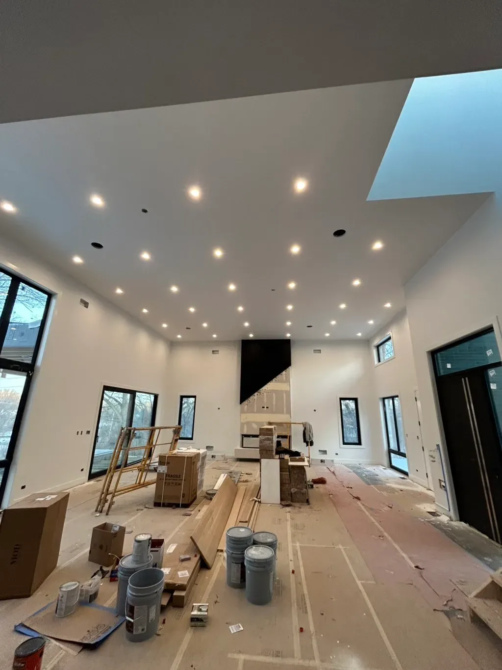 Vaulted great room during build-out with recessed lighting installed