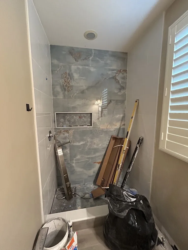 Stone-look accent wall shower mid-build with tools on site